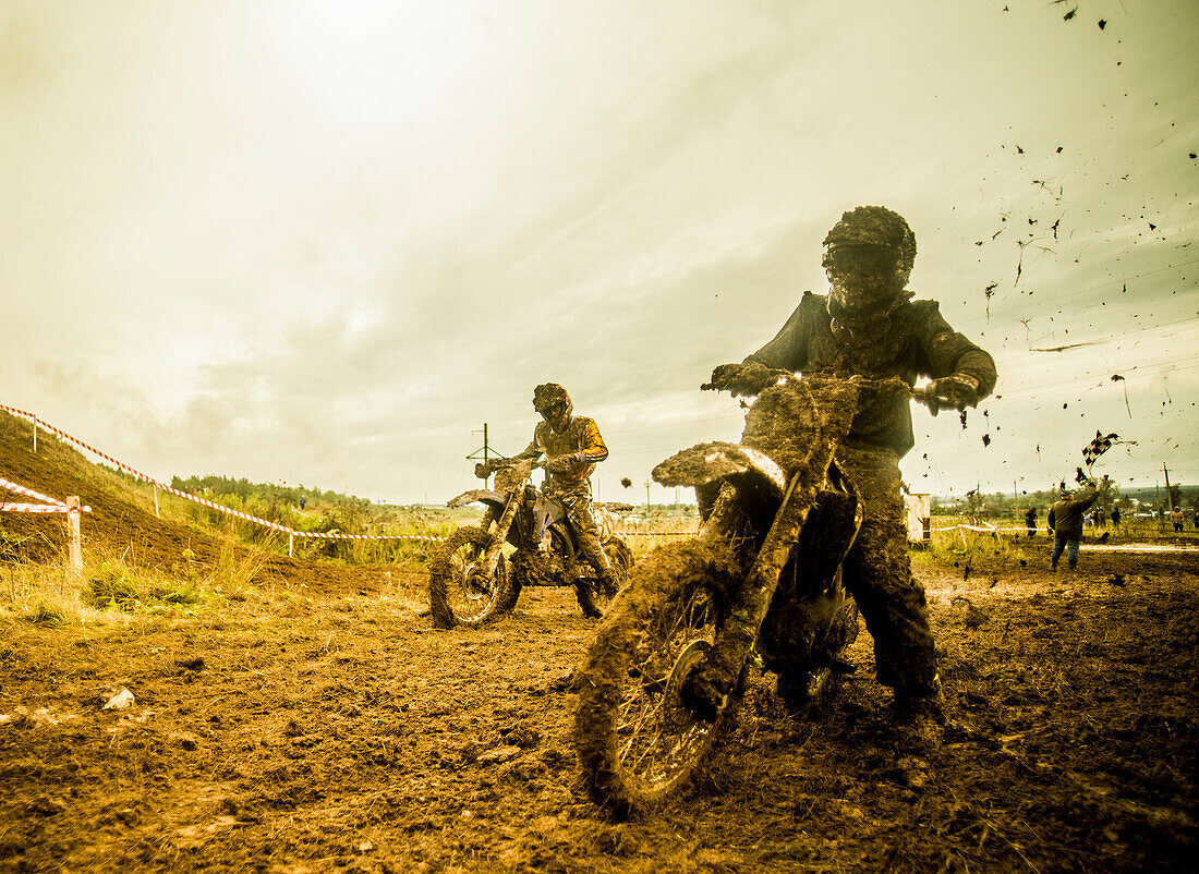 Two boys racing motorcycles at motocross