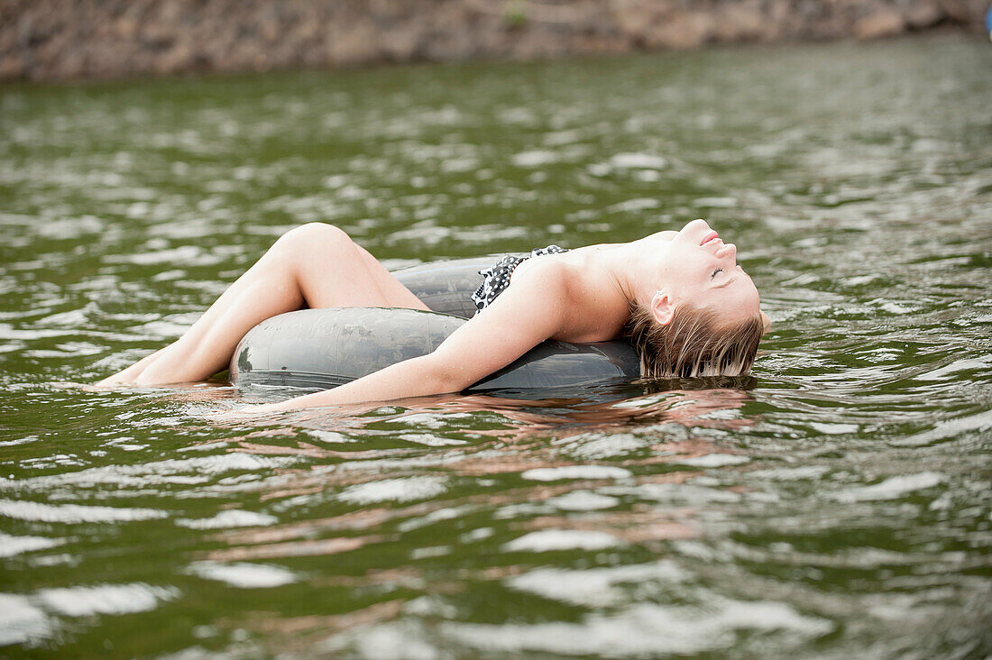 Young woman floating in inflatable ring