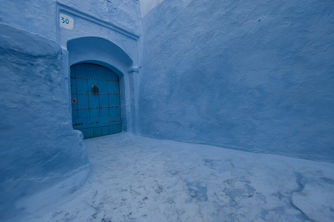 Blue door between blue walls in the blue city of Chefchaouen, Morocco