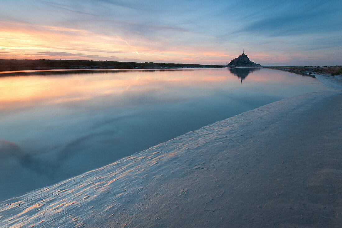 Couesnon river with high tide at sunset with Mont Saint Michel in the background, France