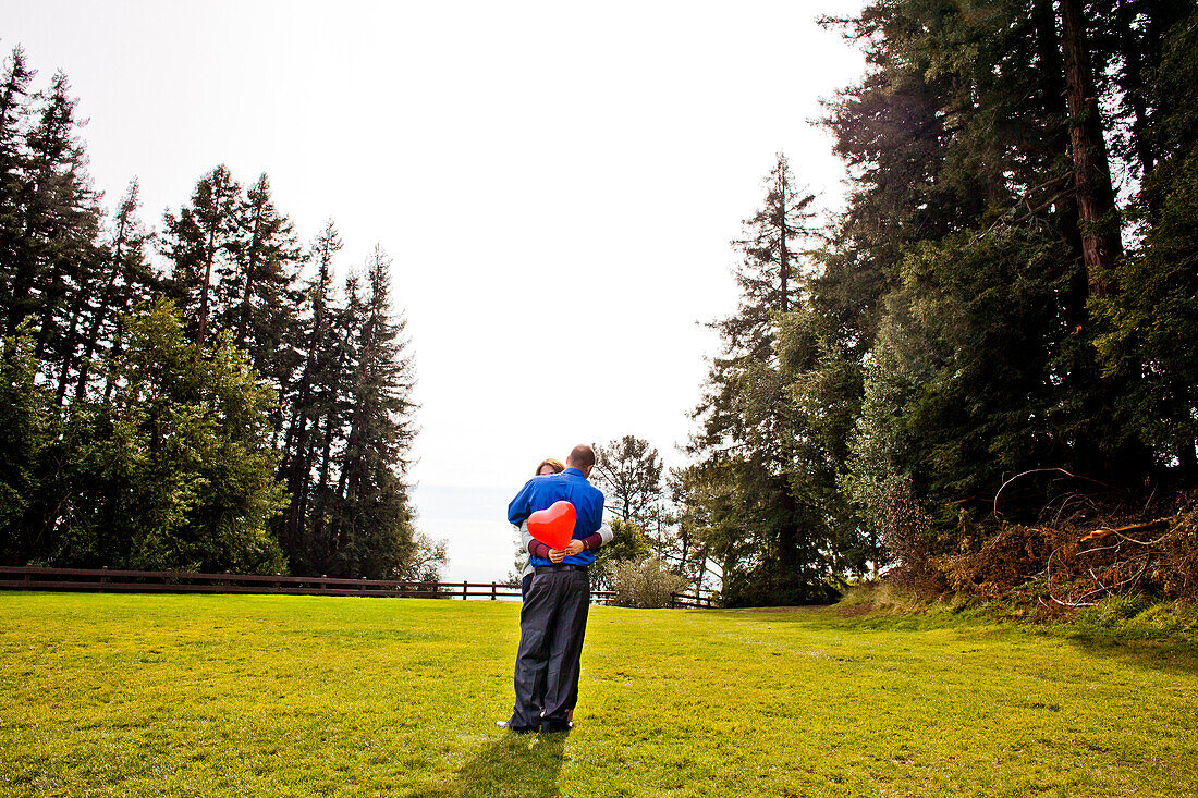 Hispanic couple hugging in park, Oakland, California, United States