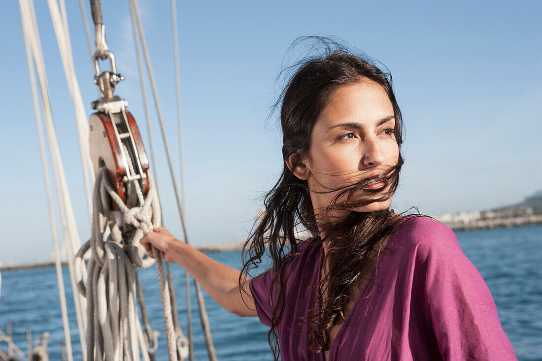 Caucasian woman hoisting sail on sailboat, Cape Town, Western Cape, South Africa