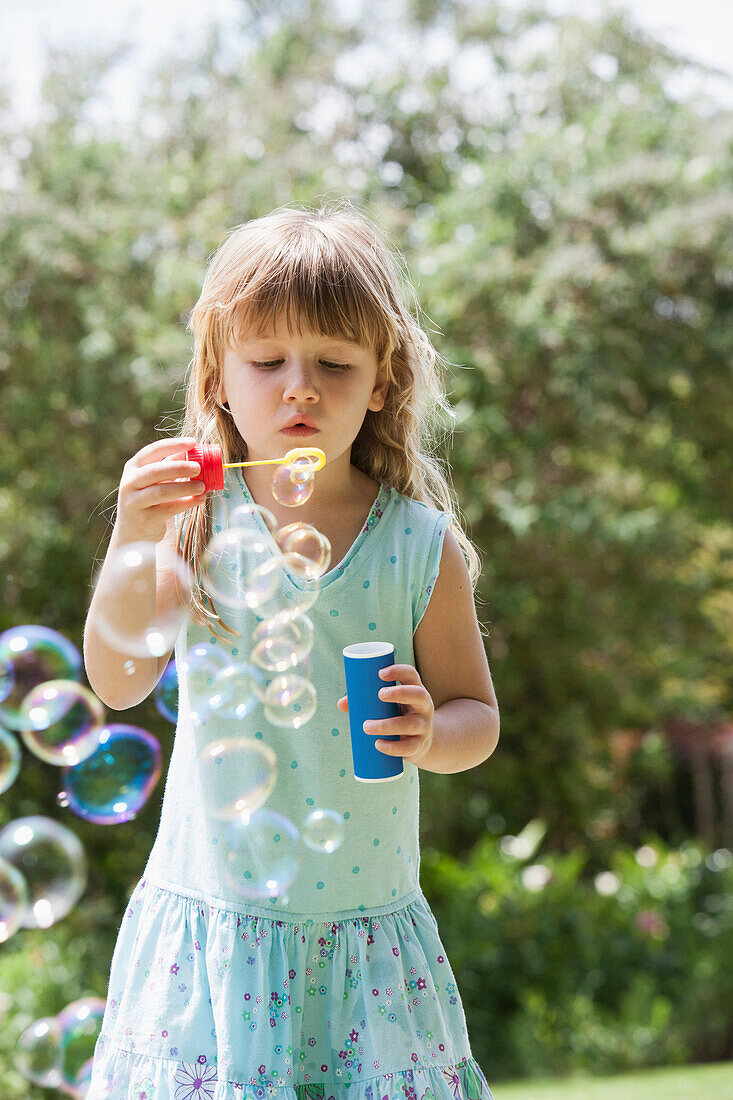 Caucasian girl blowing bubbles outdoors, Cape Town, Western Cape, South Africa