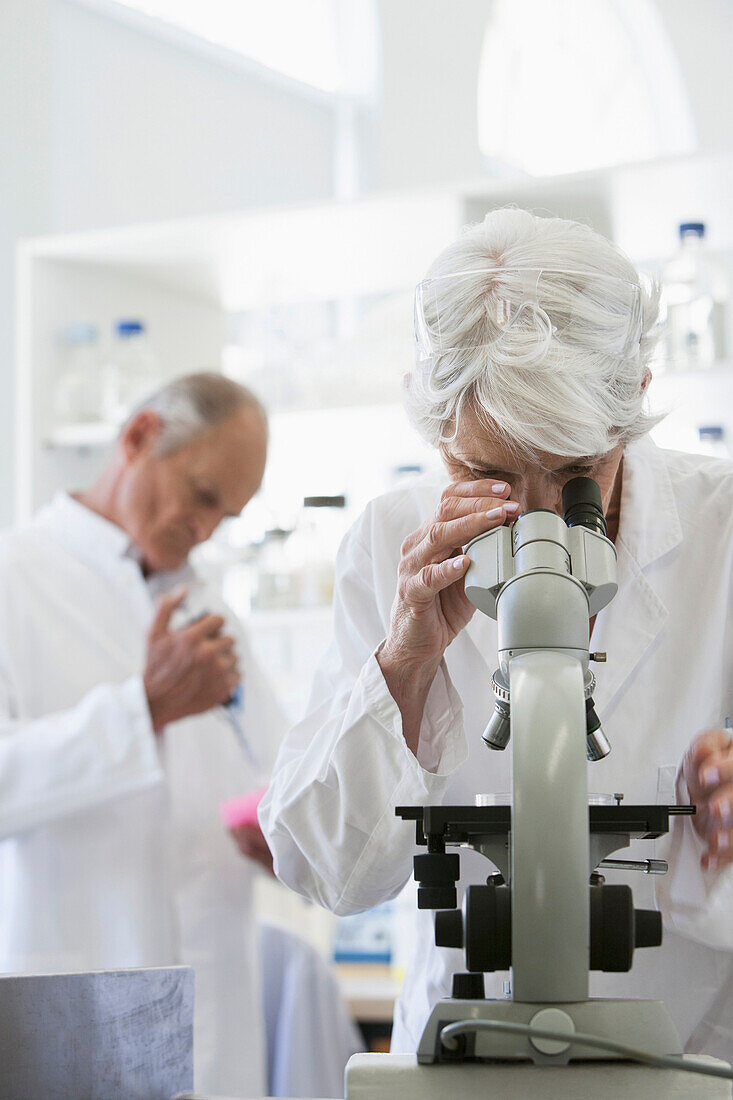 Senior Caucasian scientist using microscope in lab, Cape Town, Western Cape, South Africa