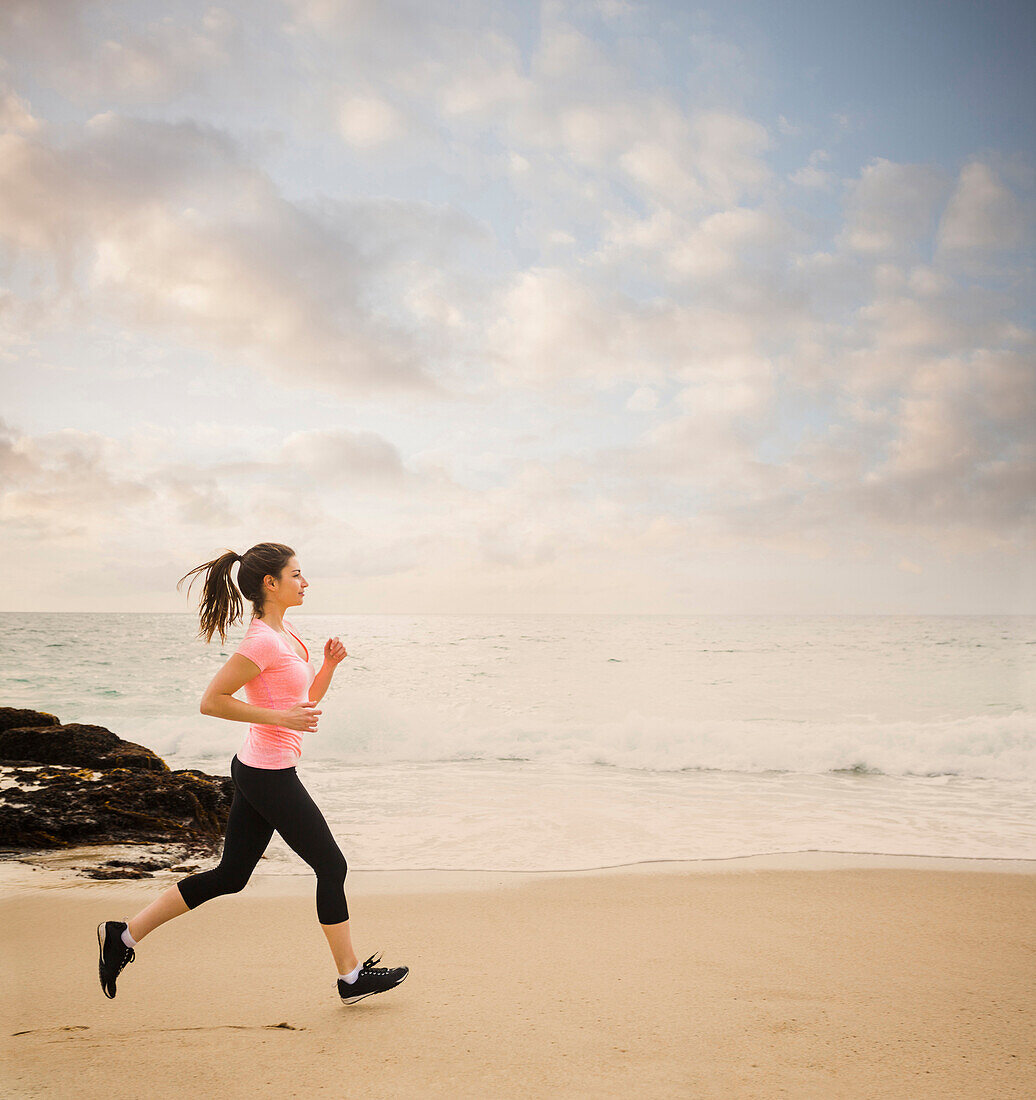 Caucasian woman running on beach, Los Angeles, California, USA