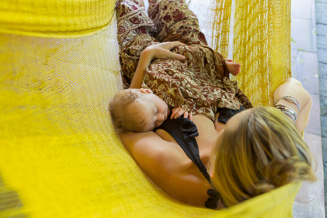 Caucasian mother and baby relaxing in hammock, Ubud, Bali, Indonesia