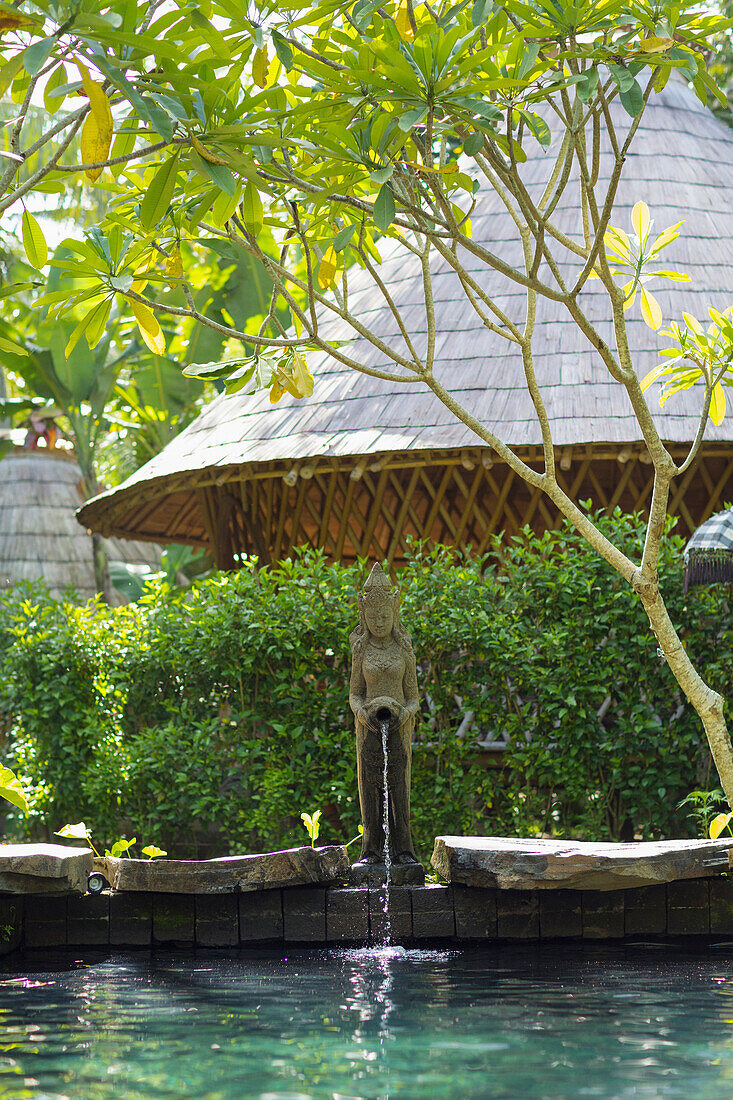 Statue fountain emptying into tropical pool, Ubud, Bali, Indonesia
