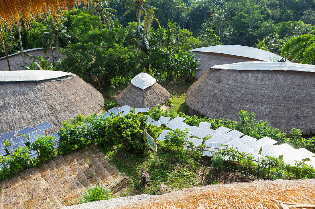 Solar panels among thatched roof buildings, Ubud, Bali, Indonesia