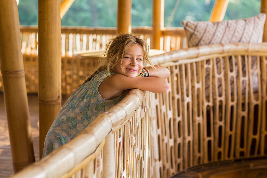 Caucasian girl leaning over railing, Ubud, Bali, Indonesia