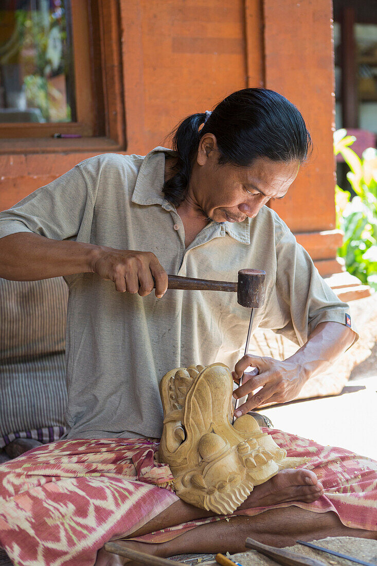 Wood worker chiseling piece in studio, Mas, Bali, Indonesia