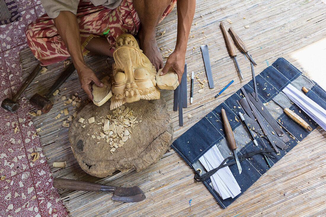 Craftsperson shaping wooden piece in studio, Mas, Bali, Indonesia