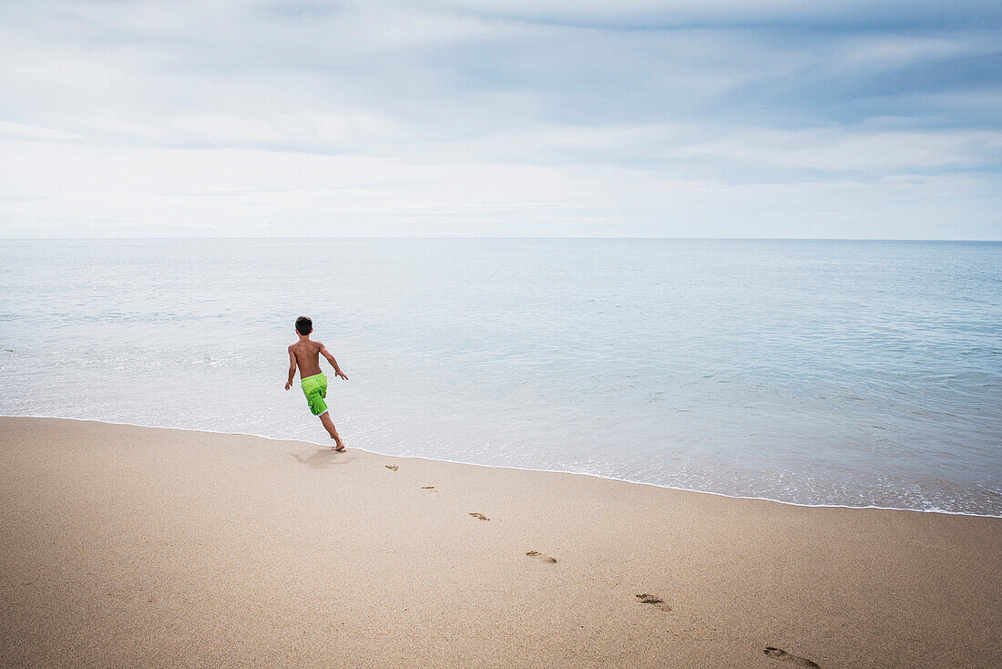 Mixed race boy playing on beach, Sayulita, Nayarit, Mexico