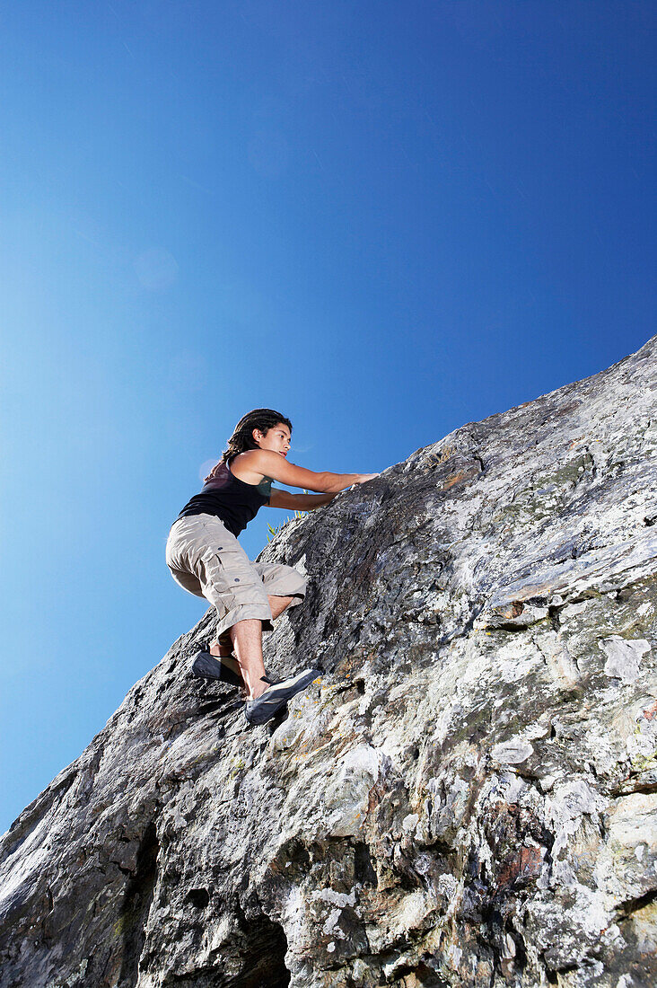 Hispanic climber scaling steep rock face, Tiburon, CA, USA