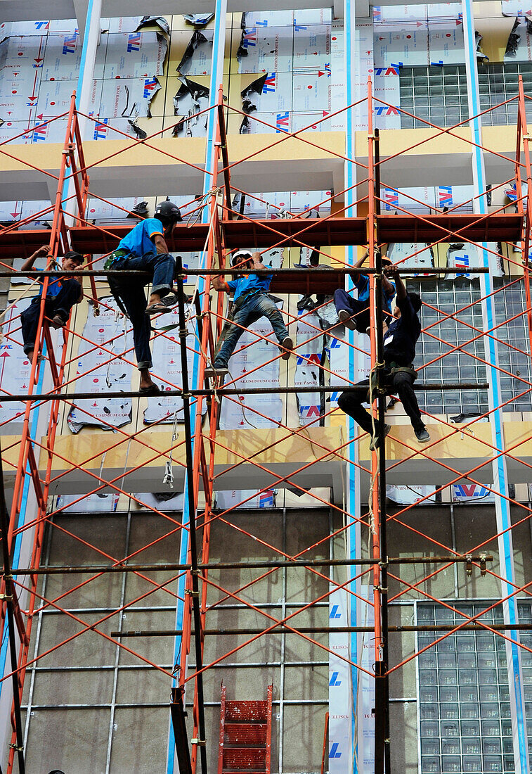 Workers in a hardhat navigating scaffolding in a major construction project  in Ho Chi Minh City, Vietnam, South East Asia, Asia
