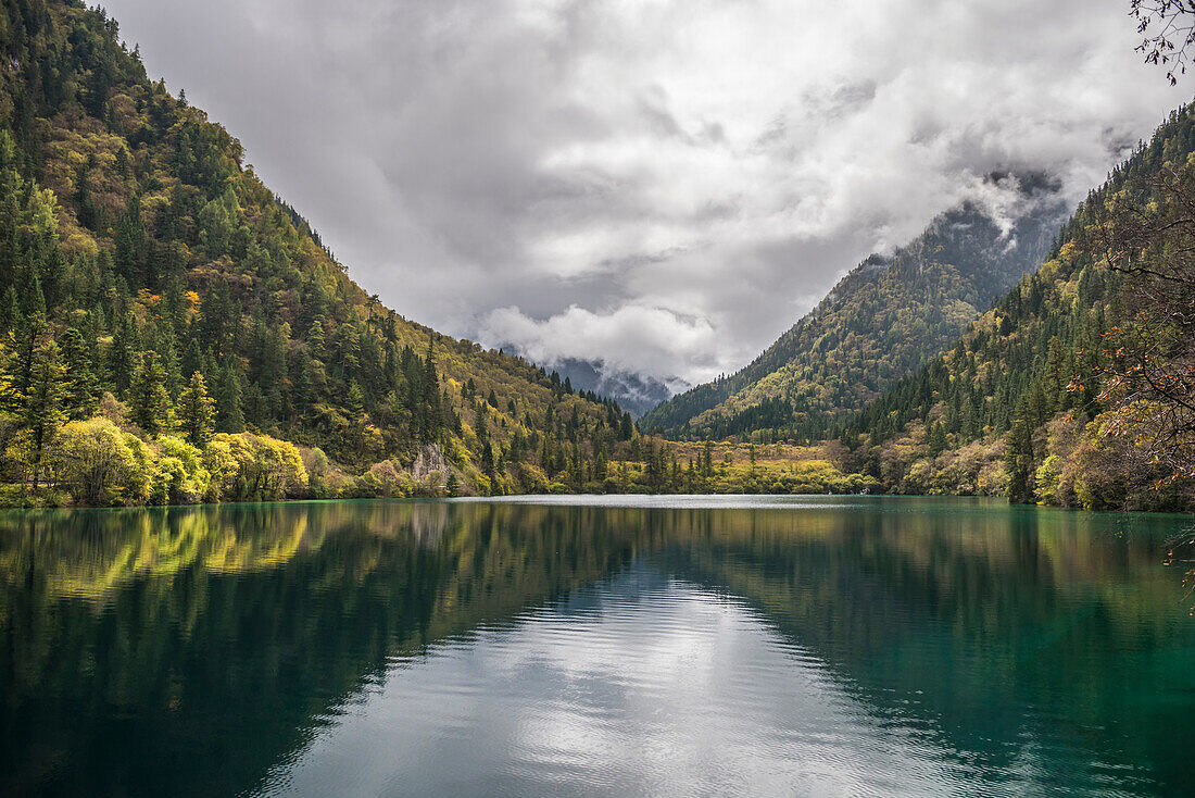 'Beautiful Landscape Of Jiuzhaigou Valley With Forests, Lake, And Mountains Under A Cloudy Sky; Jiuzhaigou, Sichuan, China'