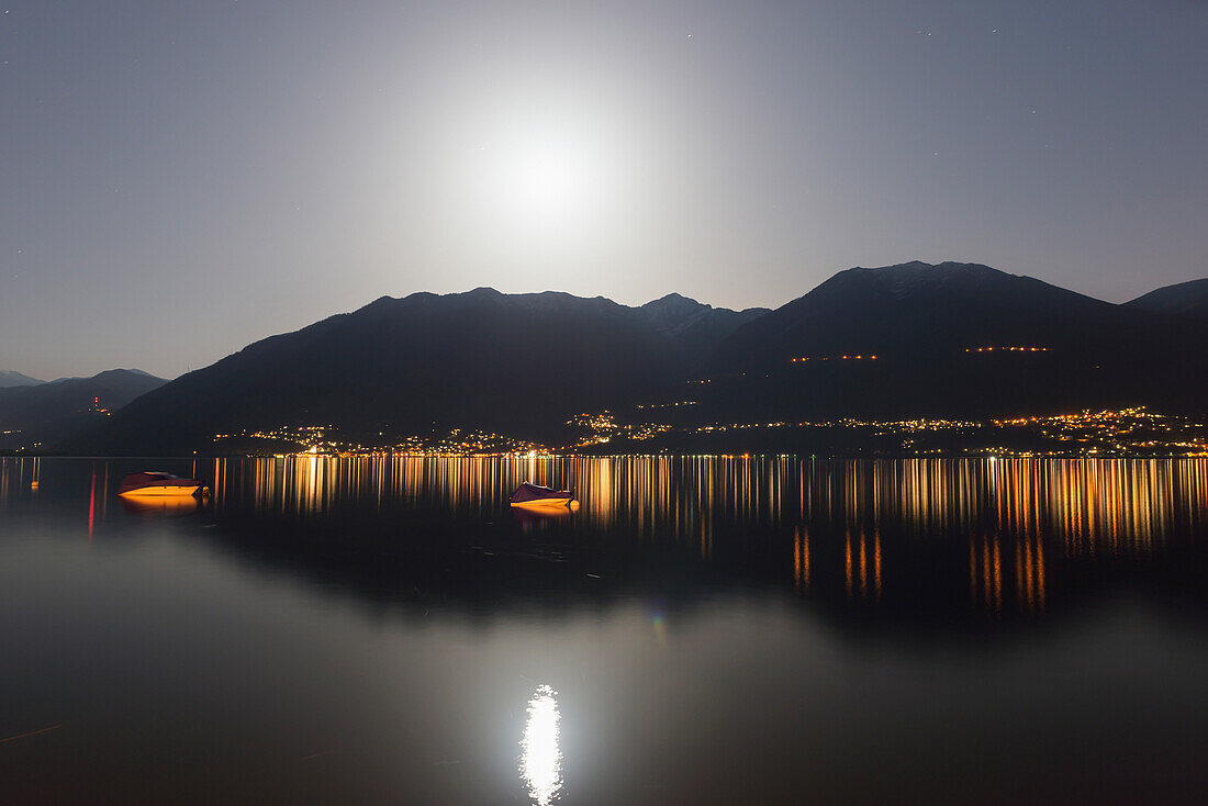 'Lake Maggiore And The Swiss Alps Illuminated By Moonlight At Night; Locarno, Ticino, Switzerland'