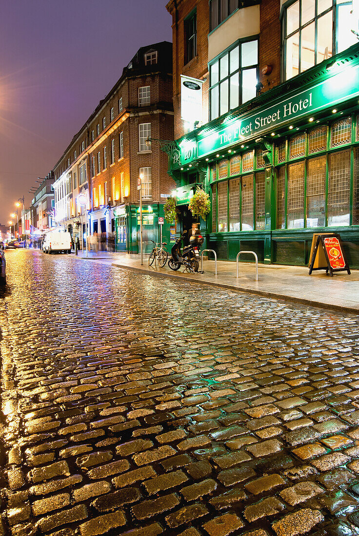 'Wet Street And Lights Illuminating Buildings At Nighttime; Dublin, Ireland'