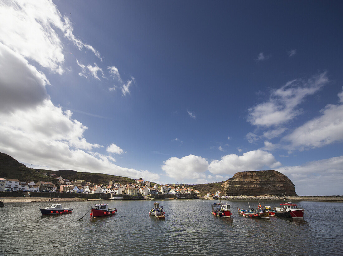 'Boats Mooring In A Row In A Harbour With Houses Along The Waterfront; Staithes, Yorkshire, England'