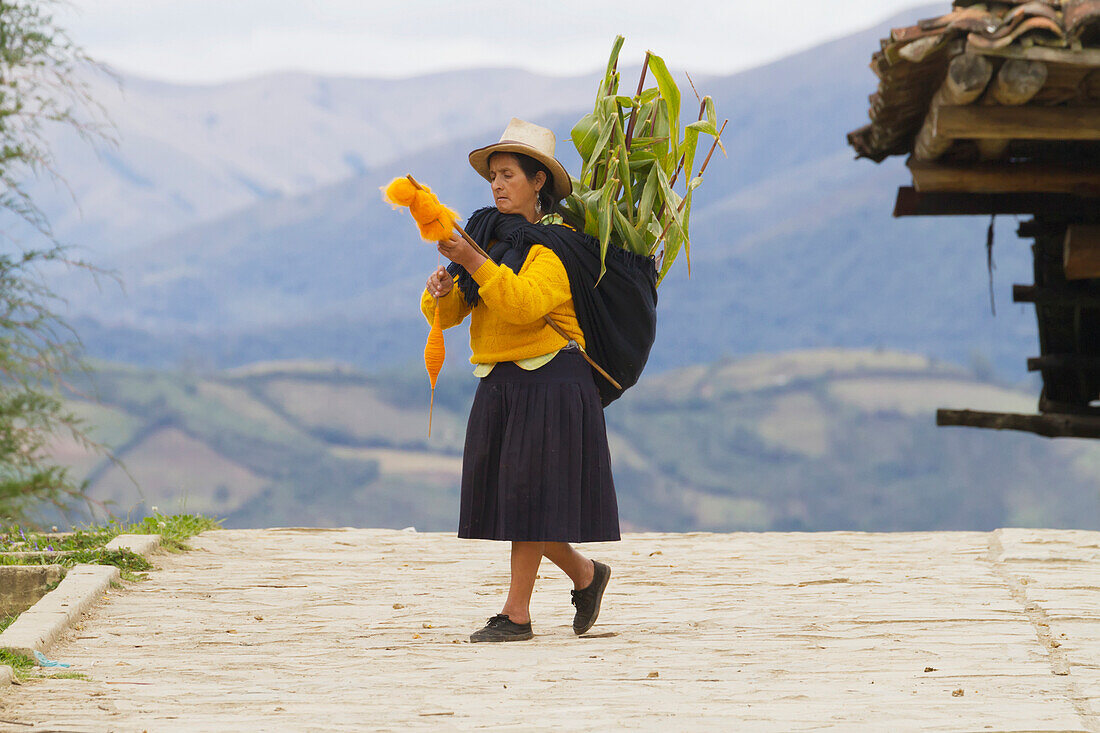 Woman carrying corn and spinning wool, San Bartolo, Amazonas, Peru