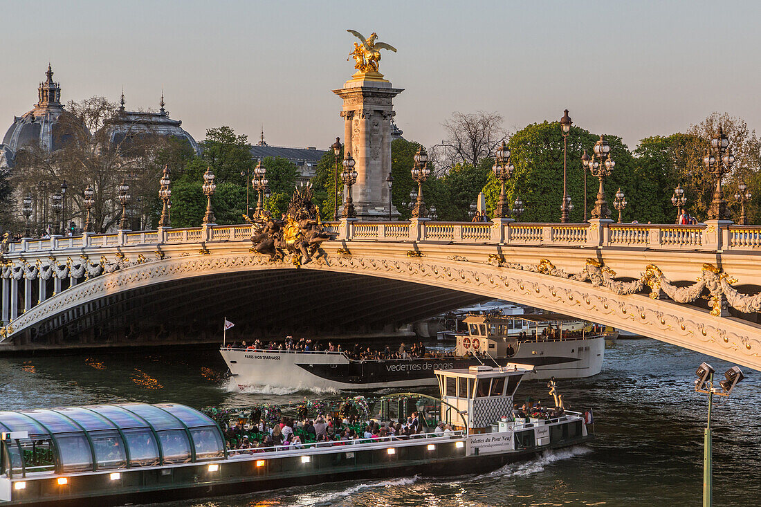 Cruise on the seine and ferries below the pont alexandre iii bridge at the end of the day, 7th arrondissement, paris, france