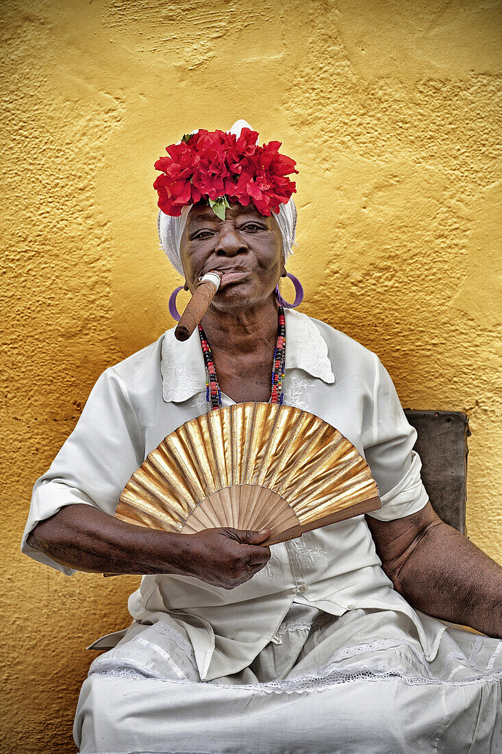 Creole woman smoking a puro cigar posing for the photo with her fan, street scene, daily life, havana vieja, cuba