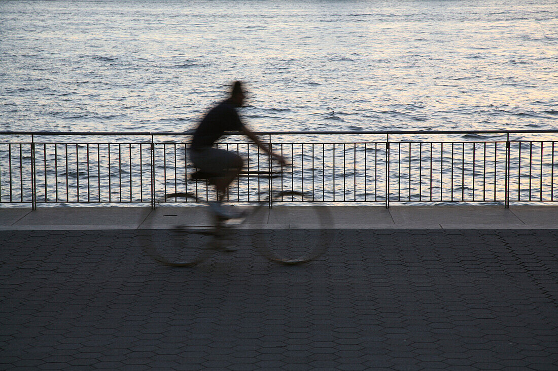 Blurry Bicycle Rider by Water