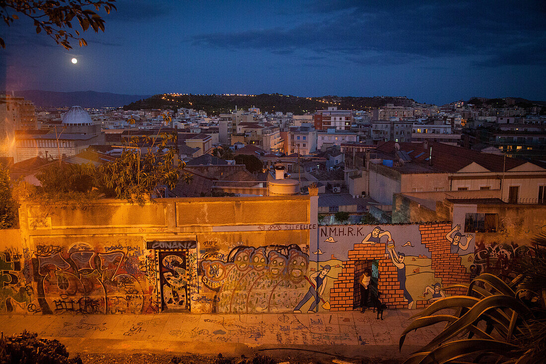 Cagliari at nightfall, graffiti on a wall on a dead-end street, sardinia, italy