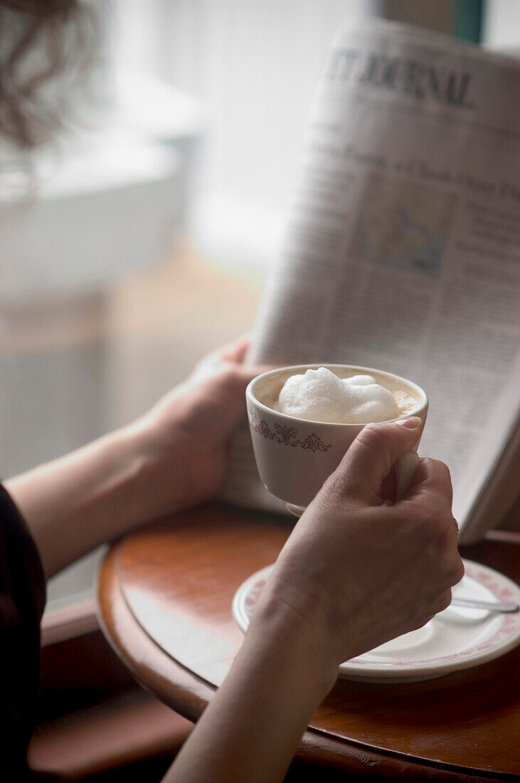 Woman with Coffee and Newspaper