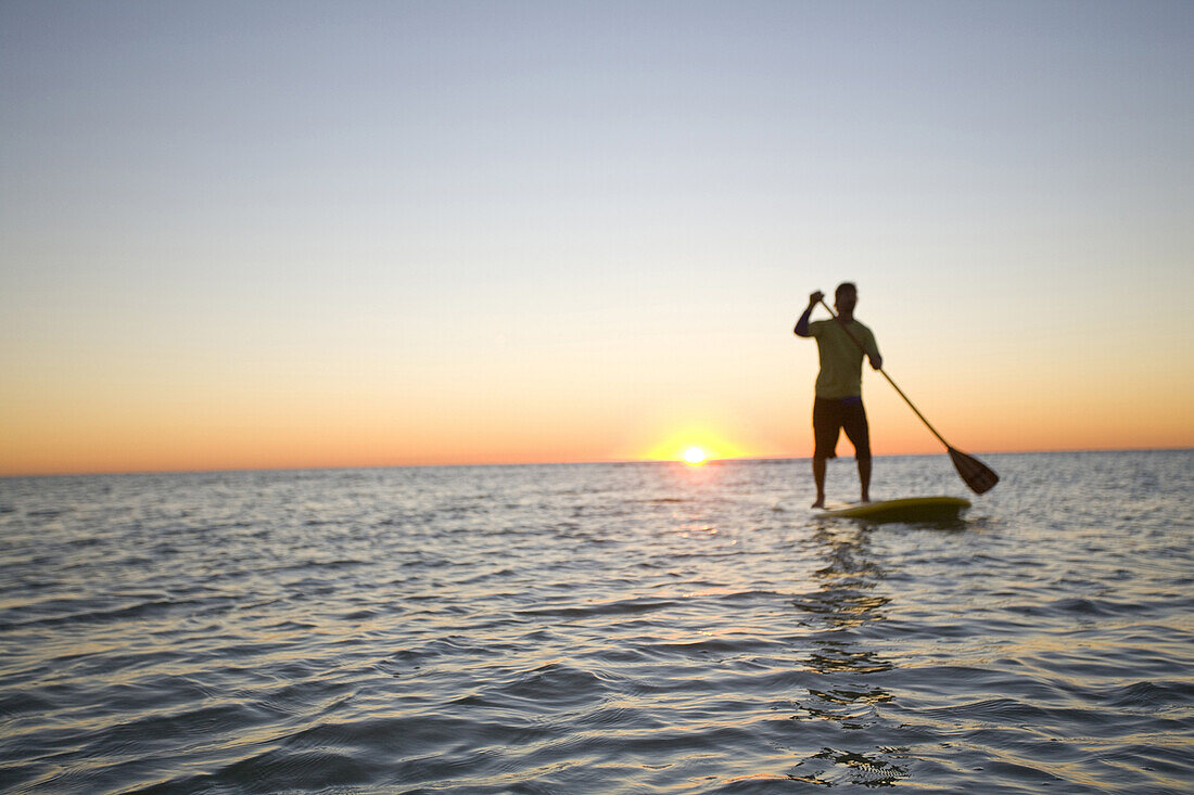 Man Paddleboarding on Ocean at Sunrise, Florida Keys, USA