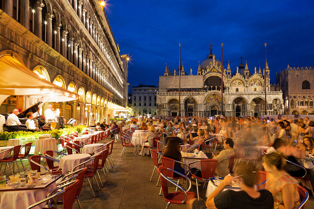 Musicians entertaining customers outside cafe in St. Mark's Square at night with the Basilica di San Marco (St. Mark's Basilica in the background, Venice, UNESCO World Heritage Site, Veneto, Italy, Europe