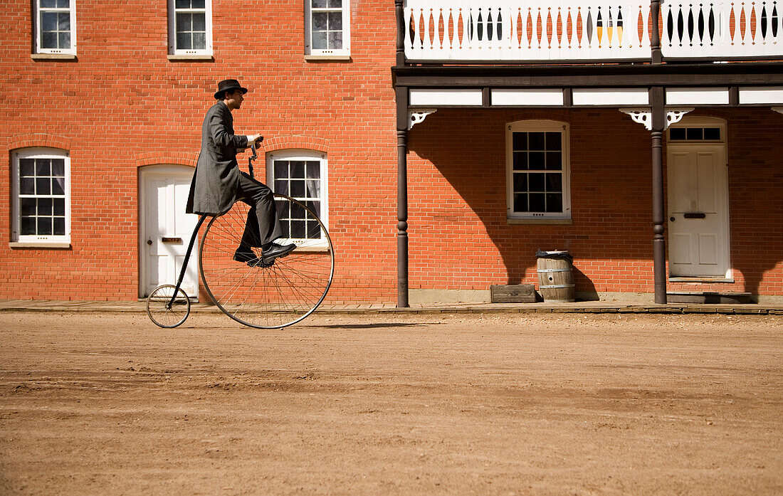 Man Riding Antique Bicycle