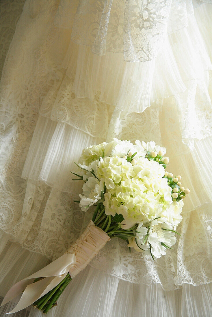 Flower Bouquet Against Wedding Dress