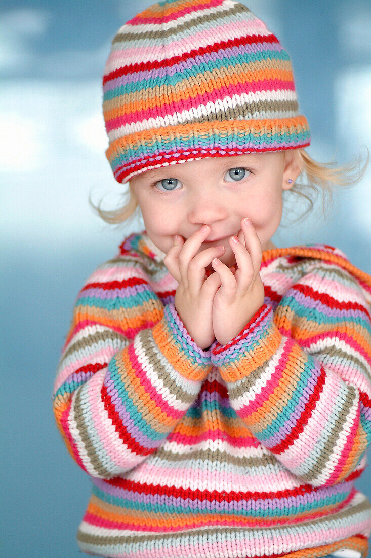 Little Girl In Colorful Hat And Sweater