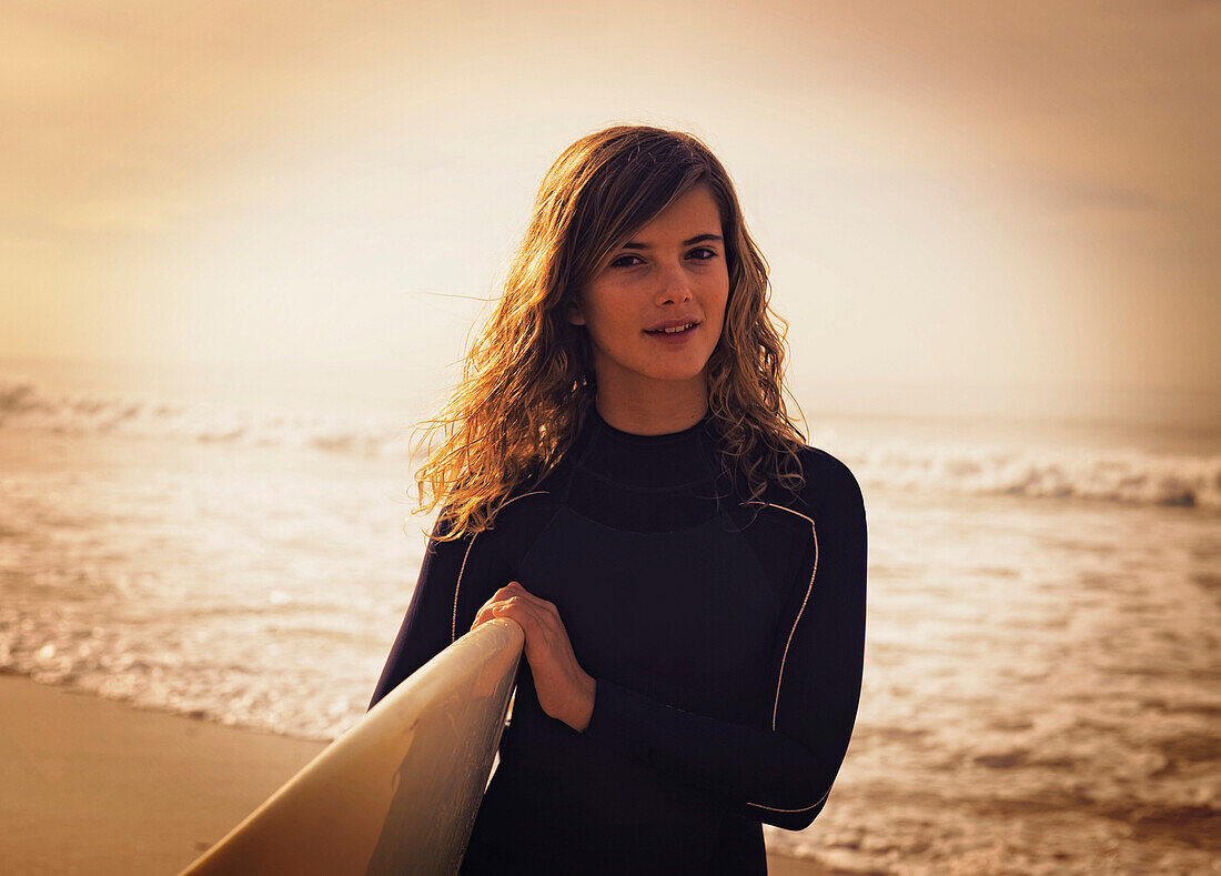 'A Young Woman With Her Surfboard At The Beach; Tarifa, Cadiz, Andalusia, Spain'