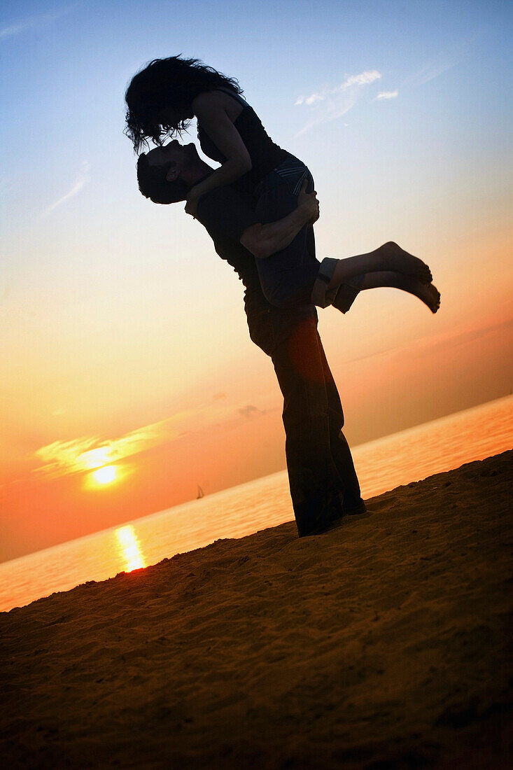 'A Man And Woman Together On A Beach In A Sunset; St. Catherine's, Ontario, Canada'