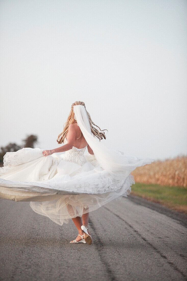 A Bride Spinning In Her Dress On The Road