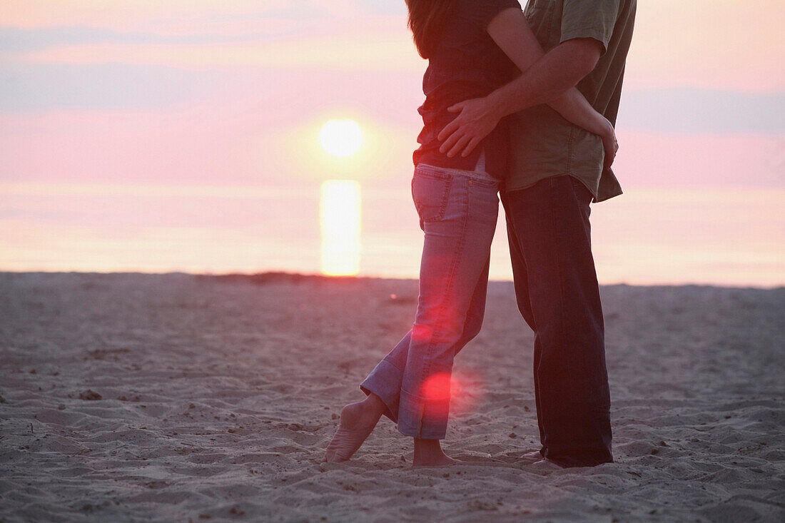 'A Couple Standing Together On A Beach At Sunset; St. Catherine's, Ontario, Canada'