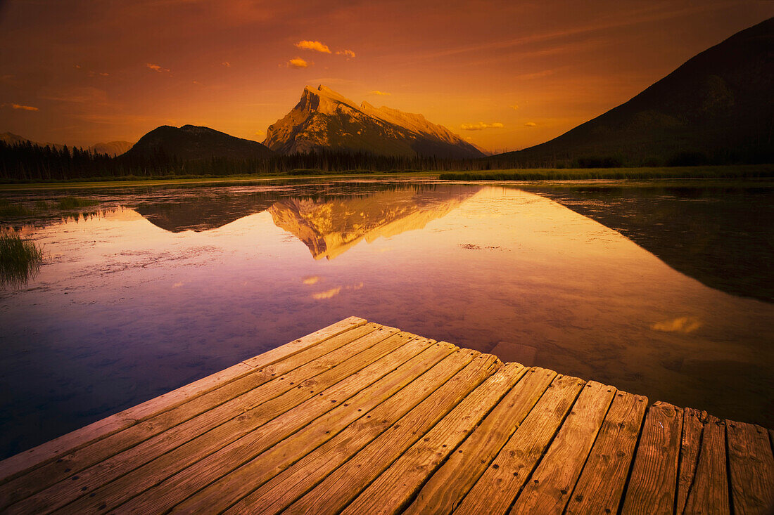 'Banff, Alberta, Canada; A Dock On A Mountain Lake During A Sunset'