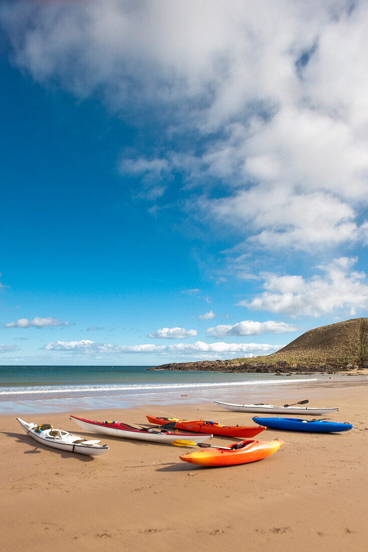 'Coldingham, Scottish Borders, Scotland; Kayaks Sitting On The Sand At The Shore'