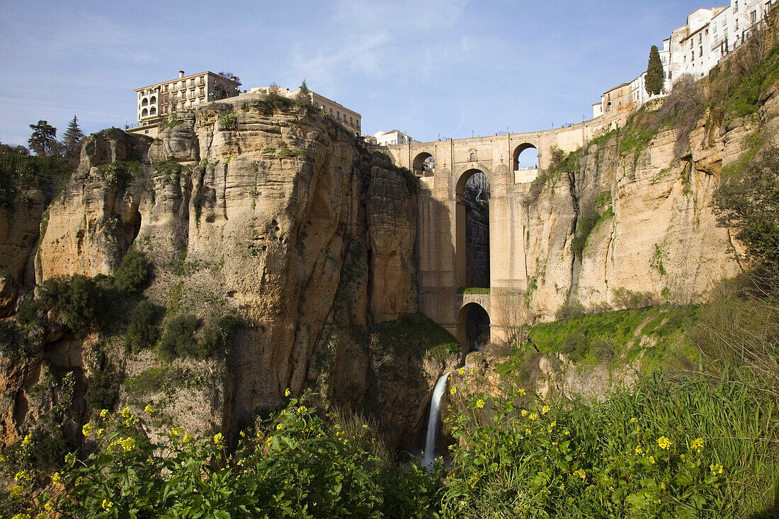 'Ronda, Andalusia, Spain; The Bridge With A Waterfall And Rock Cliffs'