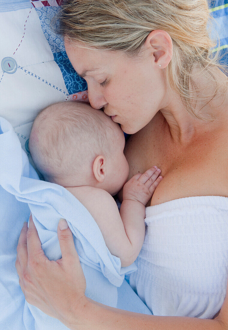 'A Mother Holds Her Baby Close With A Kiss; Banalmadena Costa, Malaga, Andalusia, Spain'