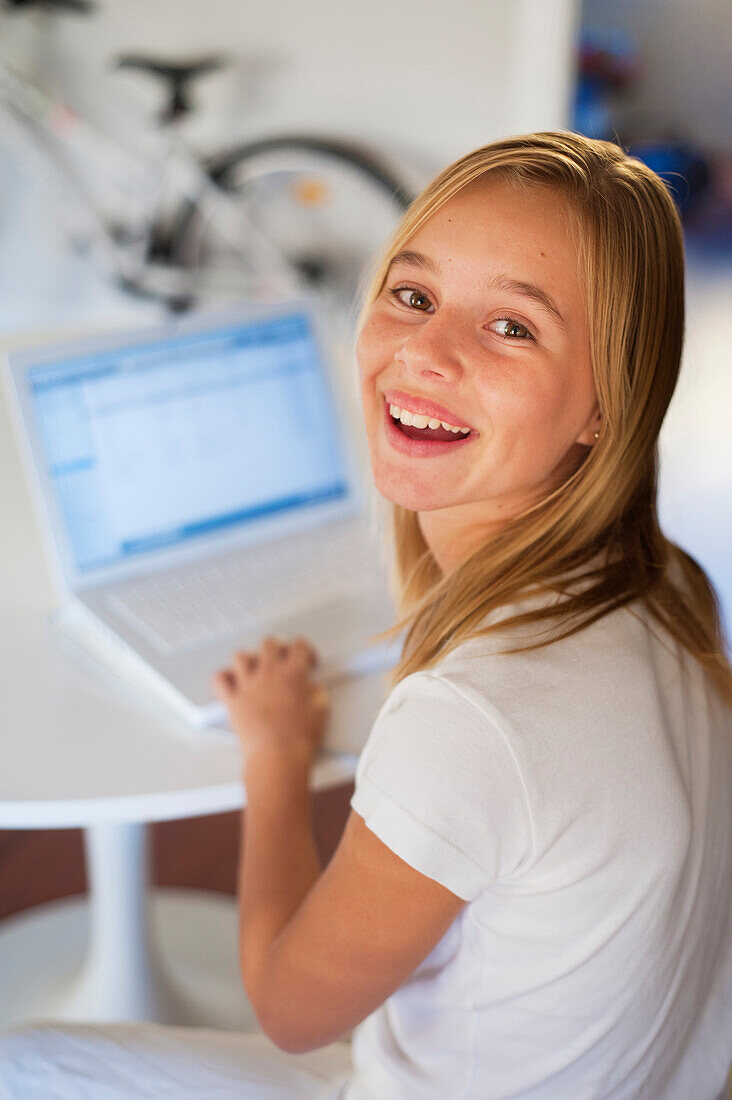 'A Girl Dress In White And Using A White Laptop Computer In A Room Furnished In White; Benalamadena Costa, Malaga, Andalusia, Spain'