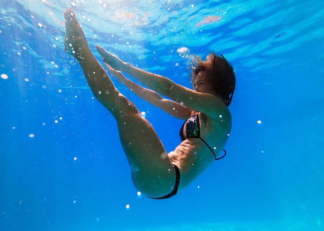 'A Girl Stretching To Touch Her Toes Under The Water; Tarifa, Cadiz, Andalusia, Spain'