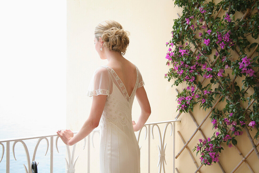 'A Woman In A White Dress Looking Out Over A Balcony; London, England'