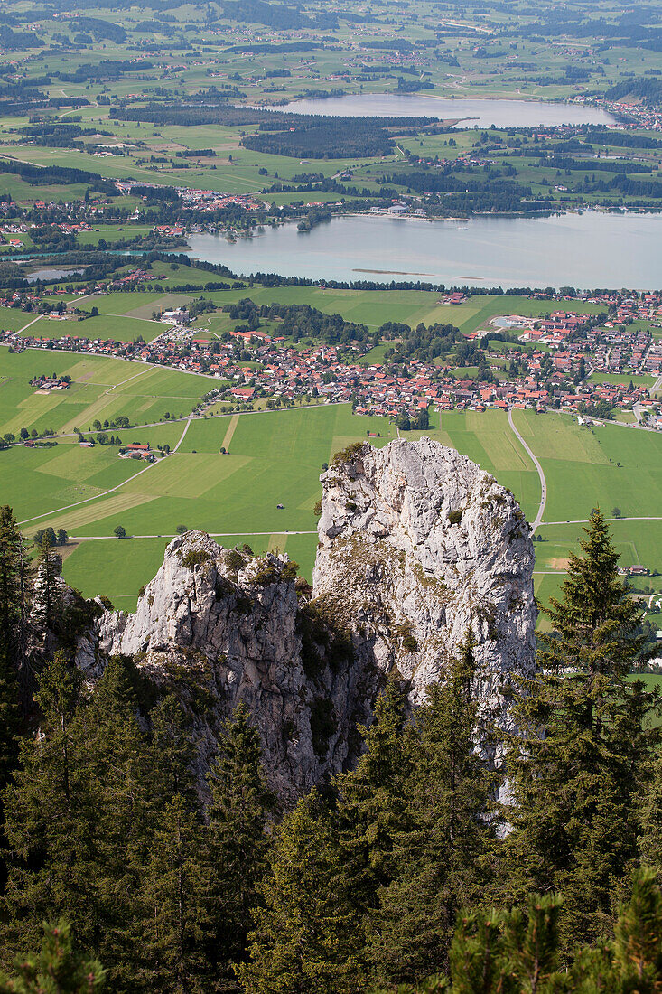 'Rock Cliffs With Trees Overlooking A Lake And Village; Fussen, Germany'