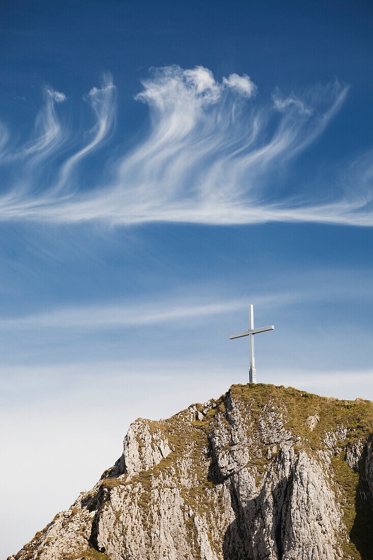 'Mountain Peak With A Cross On Top Against A Blue Sky With Clouds; Fussen, Germany'