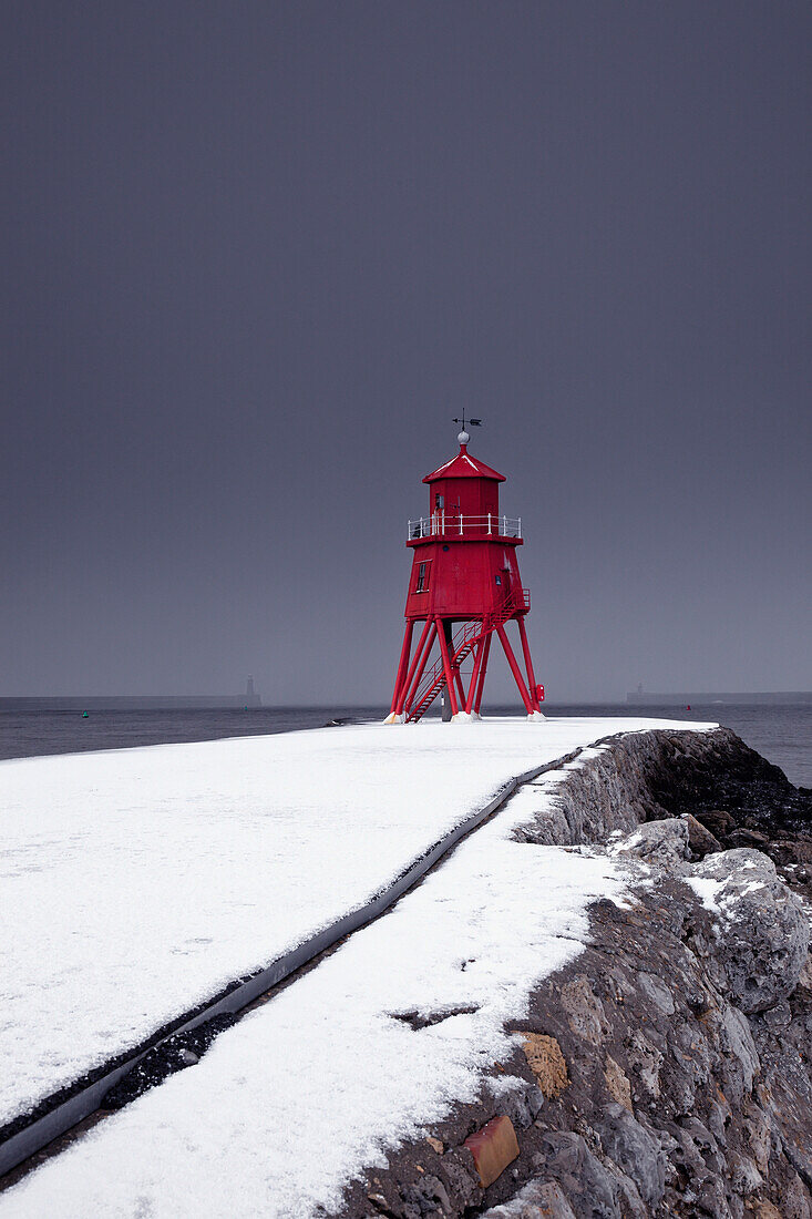 'A Red Lighthouse Under A Stormy Sky Along The Coast In Winter; South Shields, Tyne And Wear, England'