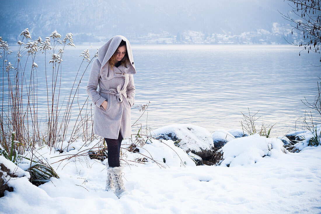 young woman walking in the snow at annecy's lake