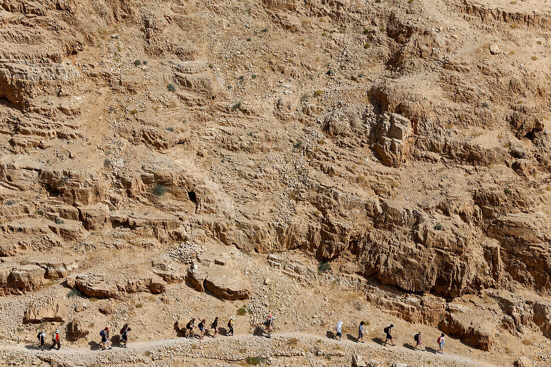 Pilgrimage in holy land. Pilgrims walking in Wadi Qelt valley. Israel.