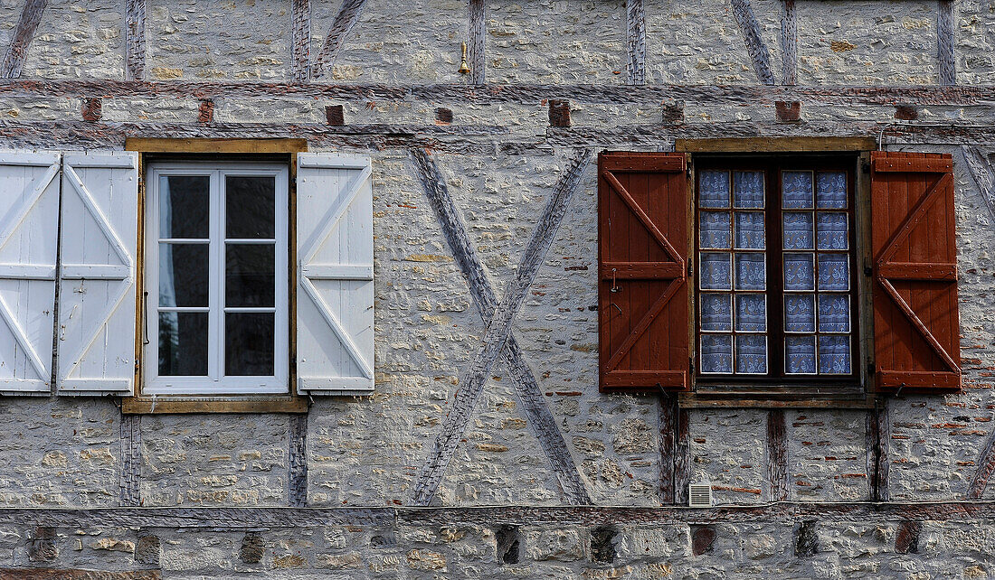 France Cahors, stone facade of an old building, two windows, green shutters and brown